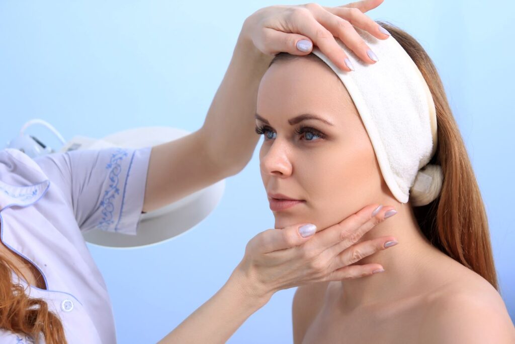 Mulher tendo seu rosto analisado após cirurgia plástica.