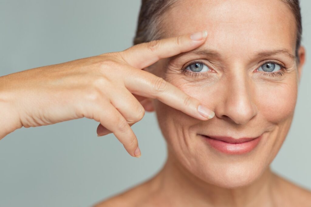 mulher mais madura, com a pele naturalmente marcada por algumas rugas ao redor dos olhos.