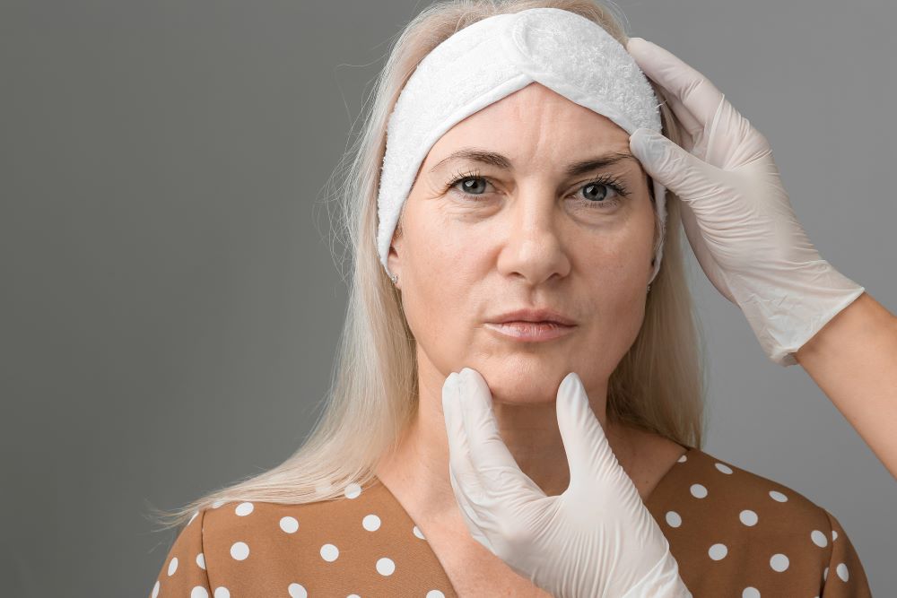 Mulher de meia-idade durante avaliação estética realizada por um profissional, ilustrando a radiofrequência facial como tratamento para flacidez, estímulo de colágeno e rejuvenescimento da pele.